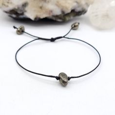 This minimal Pyrite bracelet is made with black waxed cotton cord and sliding knot that allows you to slide it over your hand and tighten it to your desired fit ◇ Meaning Pyrite is a powerful protection stone. It stimulates the intellect and enhances memory, helping to recall relevant information. Pyrite assists one in seeing behind facades, promoting an understanding of that which lies beneath words and actions. ◇ Suggestions Everyone responds differently to crystals. What works for one may not Minimalist Jewelry With Adjustable Waxed Cord, Minimalist Adjustable Waxed Cord Jewelry, Spiritual Friendship Bracelet With Sliding Knot For Everyday, Spiritual Friendship Bracelets With Sliding Knot For Everyday, Adjustable Hand Wrapped Minimalist Friendship Bracelet, Adjustable Minimalist Hand Wrapped Friendship Bracelets, Adjustable Waxed Cord Jewelry For Everyday, Minimalist Adjustable Hand Wrapped Friendship Bracelets, Hand Wrapped Adjustable Minimalist Friendship Bracelet