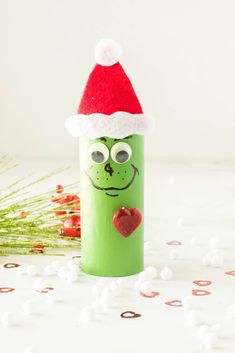 a green tube with a red heart in it and a santa hat on top of it