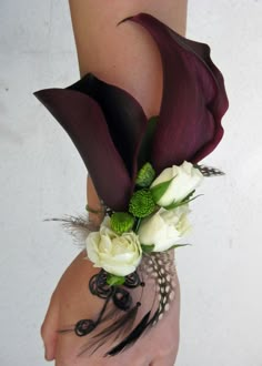 a woman's arm with flowers and feathers attached to the back of her body