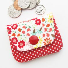 a red and white polka dot purse next to some coins