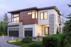 a two story house with lots of windows on the front and side of it, surrounded by greenery