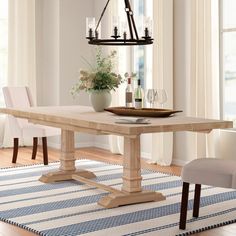 a dining room table with two chairs and a vase