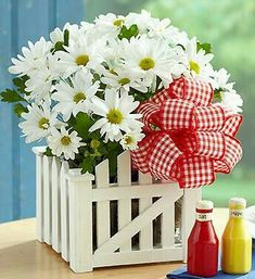 a happy may day card with daisies in a basket and juice bottles on a table