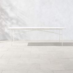 a white table sitting on top of a tiled floor next to a wall and window