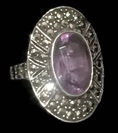 "Vintage Long Marcasite & Amethyst Ring w Art Deco Style Size 6.75 Weight 6.7g Length 1\" Width 5/8\" Rings are Delivered in a Gift Box Free Domestic USA Shipping & Free Postal Insurance If you do not want the ring polished and want to leave the natural patina please let me know at the time of purchase as I do polish rings before I ship rings out. Thanks USPS Domestic Shipping is free for buyers. If a buyer prefers to upgrade to priority, the buyer will pay that portion of the shipping c Hallmarked Oval Purple Ring, Oval Purple Hallmarked Ring, Antique Hallmarked Purple Rings, Collectible Art Deco Purple Rings, Purple Art Deco Collectible Rings, Antique Purple Ring With Center Stone, Antique Oval Amethyst Multi-stone Ring, Art Deco Amethyst Ring Jewelry, Vintage Purple Rings With Accent Stones