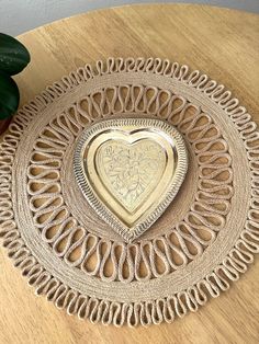 a heart shaped plate sitting on top of a wooden table next to a potted plant