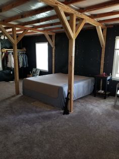 a bed sitting under a wooden frame in a bedroom