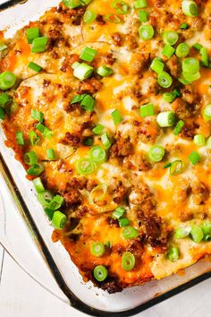 a casserole dish with meat, cheese and green onions on the top is ready to be eaten