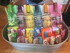 a metal bucket filled with lots of different flavored sodas and candy bar wrappers