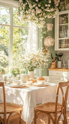 a dining room table with flowers hanging from the ceiling and plates on top of it