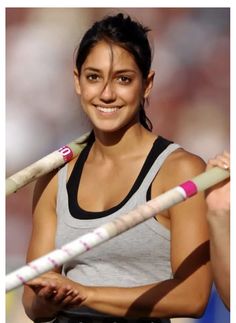 a woman holding two baseball bats in her hands