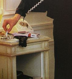 a man in a black suit is using a telephone