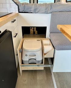 the interior of a camper with an open toilet