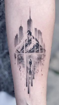 a tattoo on the leg of a person with a cityscape in the background