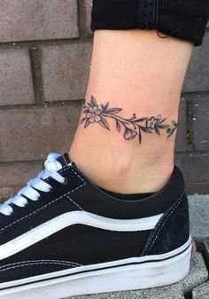 a woman's foot with a flower tattoo on the side of her shoe,