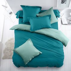 a bed with blue sheets and pillows in a room