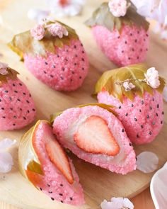 some strawberries are sitting on a wooden plate