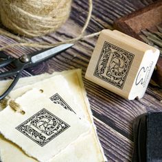 a pair of scissors and some string on a wooden table with various types of crafting supplies