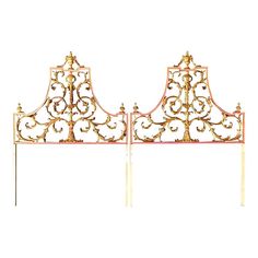 a metal headboard with ornate designs and gold paint on the top, against a white background