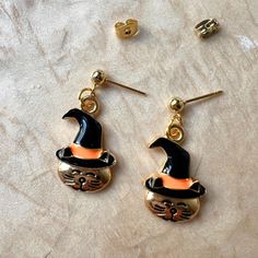 Add a touch of magic to your Halloween wardrobe with these charming Witch Cat Head Earrings! Featuring a sleek gold-colored cat head adorned with a classic black and orange witch hat, these earrings perfectly blend elegance with festive fun. The cat's playful expression and the witch hat's vibrant colors make these earrings a standout accessory for any Halloween occasion. Whether you're dressing up for a party or just want to infuse some spooky spirit into your everyday look, these lightweight a Gold Jewelry With Cat Design For Party, Witchy Gold Jewelry For Halloween, Gold Dangle Jewelry For Halloween, Gold Cat Ears Jewelry As Gift, Novelty Gold Hypoallergenic Earrings, Gold Hypoallergenic Novelty Earrings, Gold Cat Ears Jewelry Gift, Gold Cat Ears Jewelry For Gift, Halloween Cat Ears Earrings For Pierced Ears