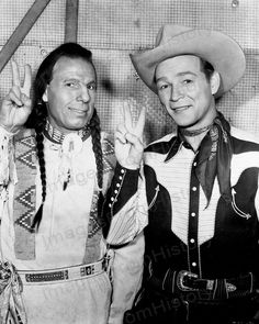 two men dressed in western wear giving the peace sign