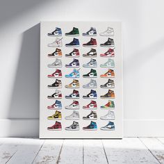 a white canvas with colorful sneakers on it in front of a white wall and wooden floor