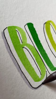 a close up of the word brolo written in green and yellow ink on white paper