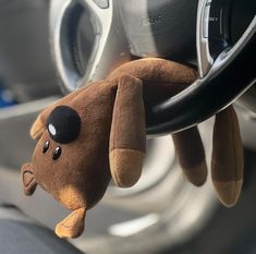 a stuffed animal hanging from the side of a steering wheel