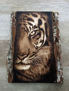 an image of a tiger on a piece of wood