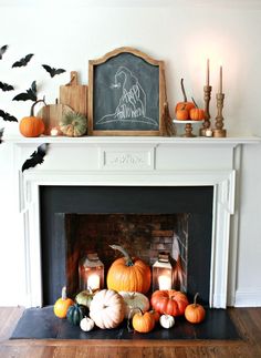 a fireplace decorated for halloween with pumpkins, candles and chalkboard on the mantle