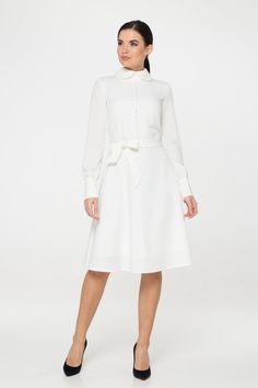 "A collared midi dress featuring a button front closure (imitation), fabric belt, and a fit and flare silhouette. - fit and flare silhouette - high rounded collar - knee length (midi) - long sleeves with cuffs - fabric belt - covered button front decor - concealed zipper closure - lined bodice and skirt - color: white Fiber: 60% viscose, 35% polyester, 5 % elastane, Lining - 95 % viscose, 5% elastane. For size S:dress length- 40,0 \" (102 cm), sleeve length 24,21\" (61,5 cm) Our model wears size Classic A-line Midi Dress For Wedding, Classic White A-line Shirt Dress, Chic A-line Long Sleeve Wedding Dress, Elegant Collared Midi Dress For Semi-formal Occasions, White Long Sleeve Midi Dress For Semi-formal Occasions, Fitted Long Sleeve Dresses With Belted Cuffs, White Long Sleeve Formal Shirt Dress, White Long Sleeve Shirt Dress For Formal Occasions, Elegant White Collared Dress