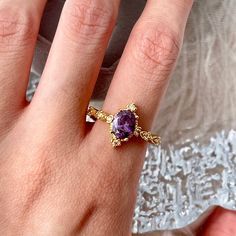 Purple oval shaped amethyst crystal gold lace ring with 8 diamond cz side tones, super delicate and beautiful. Handmade of top quality purple amethyst simulant, absolutely gorgeous, sparkly and eye catching under lights, it speaks for itself! Dainty side stones make the ring even unique and luxurious. Open band, easy to adjust for your own preferences. 💎 Features: ♥ Material: 14K Gold plated Pt950 ♥ Main stone: Purple amethyst simulant ♥ Side Stone: Cz crystal ♥ Open adjustable band, fits US size 4-10 💎 Details: ♥ Approximate Measurements: - Main stone Length: 18mm - Main stone Width: 7mm ♥ Lightweight, easy to wear ♥ Nickel/Lead Free, Hypoallergenic, good for sensitive skins 🎁 Packing & Shipping: ♥ All our jewelry will be shipped with beautiful gift wrap packaging ♥ Handwrite gift note Lilac Amethyst, Natural Pearl Earrings, Lace Ring, Baguette Ring, Gold Gemstone Ring, Beautiful Gift Wrapping, Purple Band, Long Dangle Earrings, Gold Lace