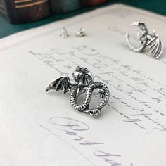 These adorable wyrmling earrings are the perfect additions to any fantasy fan's outfit! This pair of wyrmlings look as though they are nestling comfortably on your earlobes when adorned. A fantastic accessory or gift for any dragon lover. Material: Zinc Alloy Click ADD TO CART To Order Yours Now! The Checkout Process is Guaranteed to be 100% Safe and Secure with Visa, Mastercard, AMex, Discover, Apple Pay or PayPal. Fantasy Style Pierced Cartilage Earrings For Gift, Fantasy Style Silver Cartilage Earrings For Gifts, Silver Fantasy Style Cartilage Earrings As Gift, Silver Fantasy Cartilage Earrings For Gift, Flying Dragon, Stud Earrings For Men, Dragon Lover, Earrings For Men, Popular Jewelry