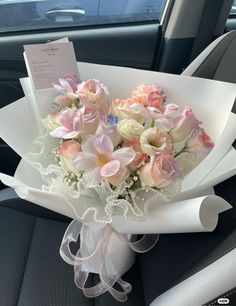 a bouquet of flowers sitting in the back seat of a car with a note attached to it