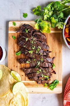 steak with salsa and tortilla chips on a wooden cutting board next to it