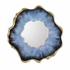 a blue and gold plate with a circular mirror on it's side, in the shape of a flower