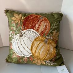 a decorative pillow with three pumpkins on it