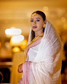 a woman wearing a white and pink sari