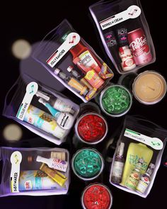 an assortment of cosmetics in plastic containers on a black surface with lights around them and the contents inside