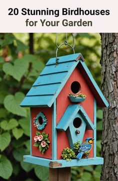 a birdhouse with flowers and birds hanging from it's sides in front of a tree