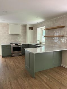 an empty kitchen with wood floors and white cabinets