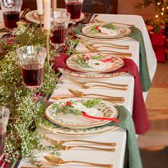 a table set for christmas dinner with plates and silverware