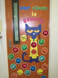 a door decorated with buttons and an image of a cat that says our class is grooy