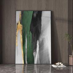 an abstract painting hangs on the wall next to a potted plant and other items