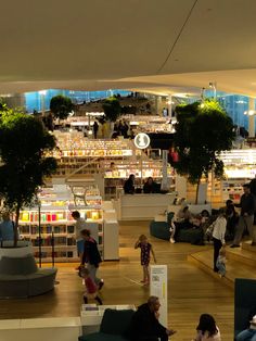 people are sitting and standing around in the library with bookshelves full of books