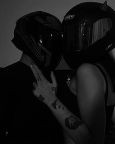 two people wearing helmets are hugging each other