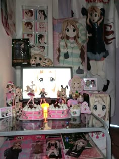 there are many anime themed items on the table in front of the computer screen, including cakes and figurines