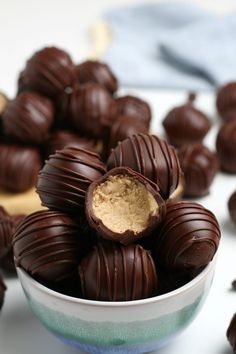 a bowl full of chocolate truffles with peanut butter in the middle on a table