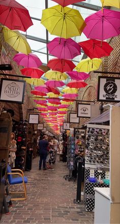 many colorful umbrellas are hanging from the ceiling