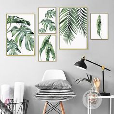 three green palm leaves are hanging on the wall above a white chair and black lamp